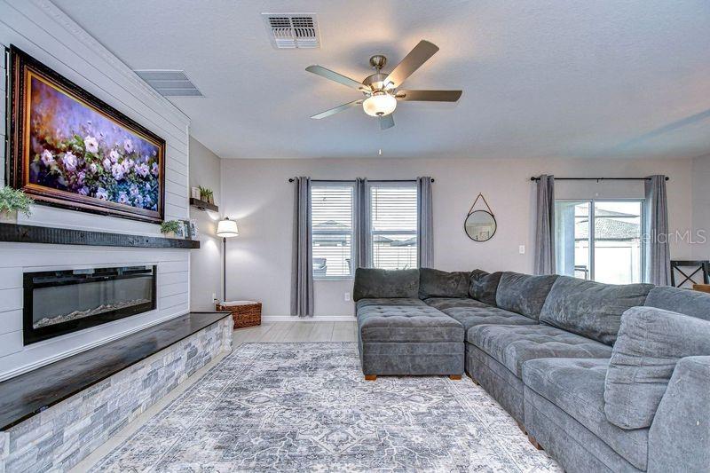 Family room with upgraded custom fireplace accented with Cypress wood hearth and mantle.