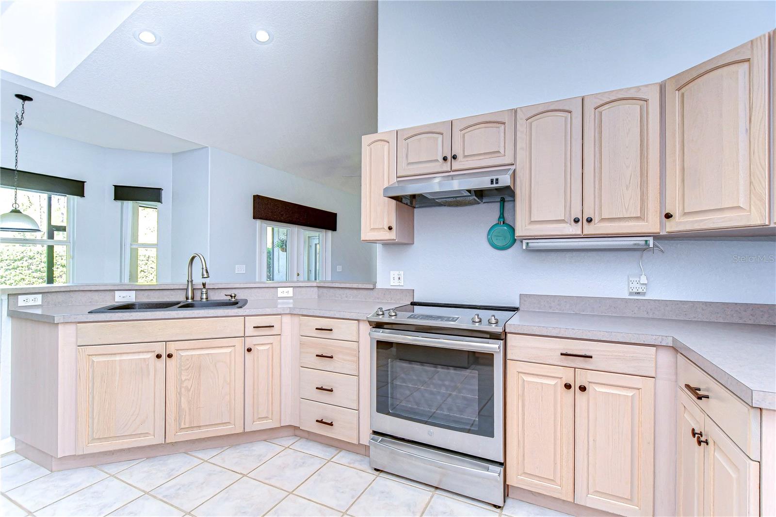 Bright and inviting, this kitchen boasts elegant cabinetry, a sleek modern stove, and ample counter space for your culinary adventures.