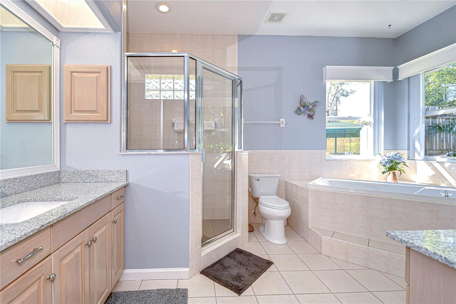 Indulge in relaxation with this sunlit bathroom oasis, featuring a spacious soaking tub and sleek modern finishes.