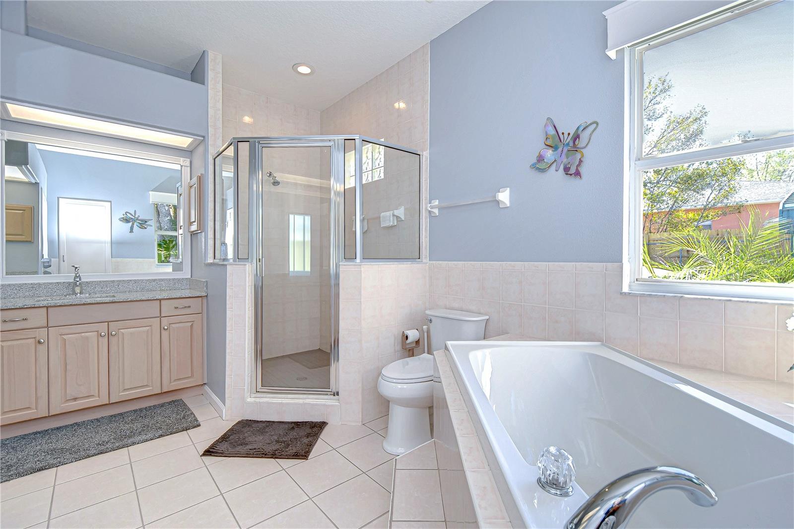 Unwind in this spa-like bathroom retreat featuring a spacious shower and a relaxing soaking tub