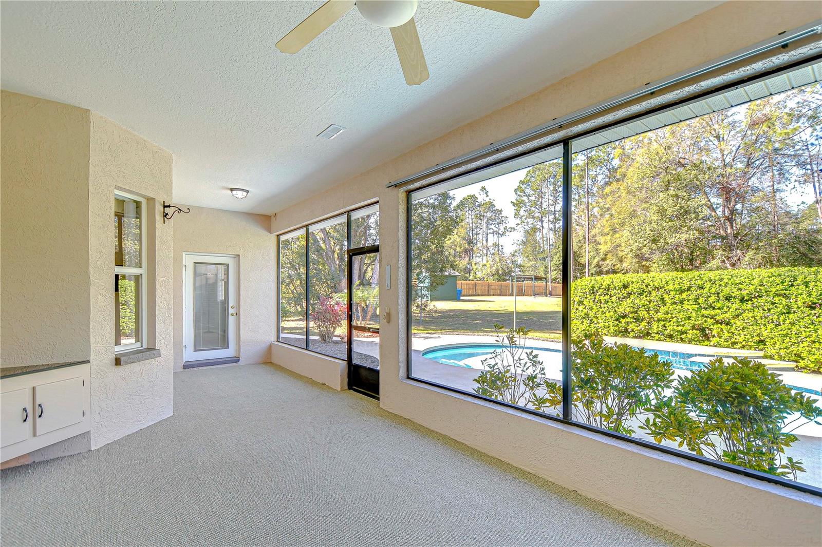 Bask in the Florida sunshine from this spacious, screened patio overlooking a sparkling pool and lush backyard.