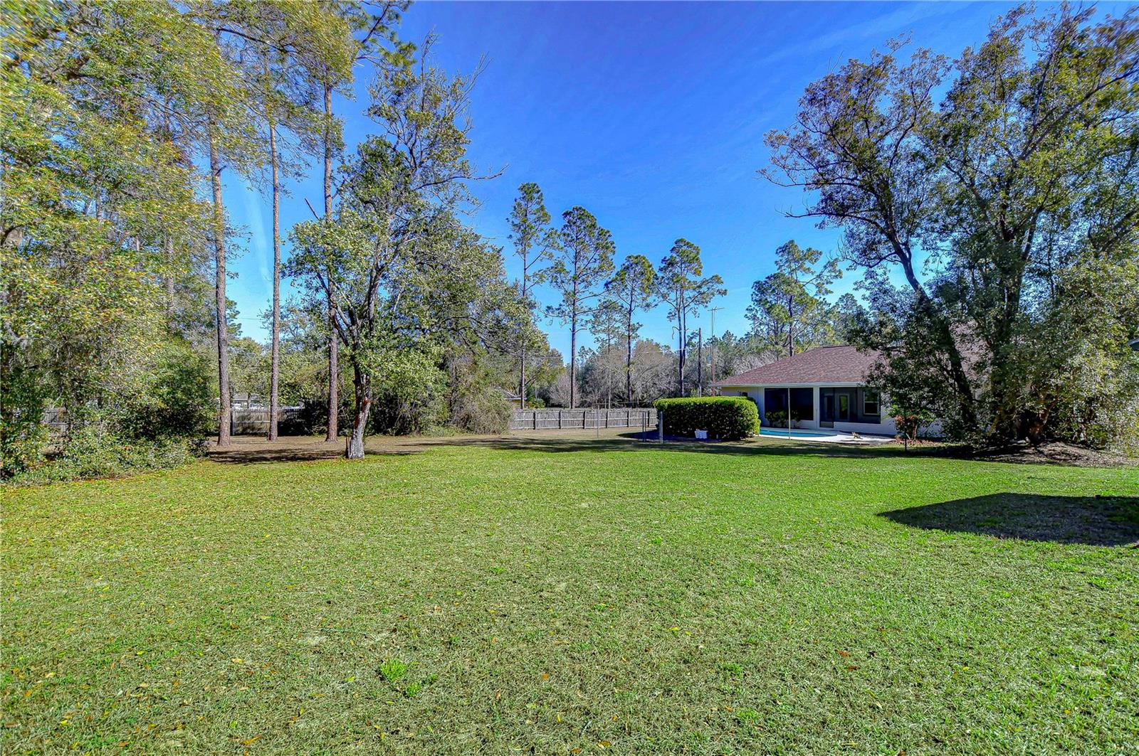 Embrace tranquility on this expansive, sun-soaked lawn, perfect for backyard barbecues or simply savoring the peace of nature.