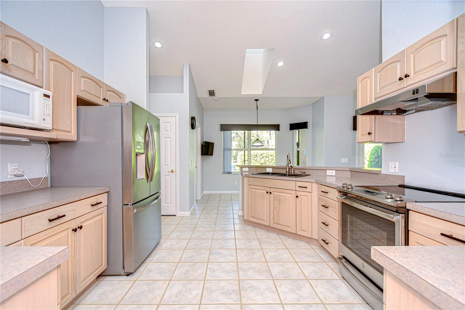 Bright and inviting, this kitchen boasts sleek stainless steel appliances and ample counter space.