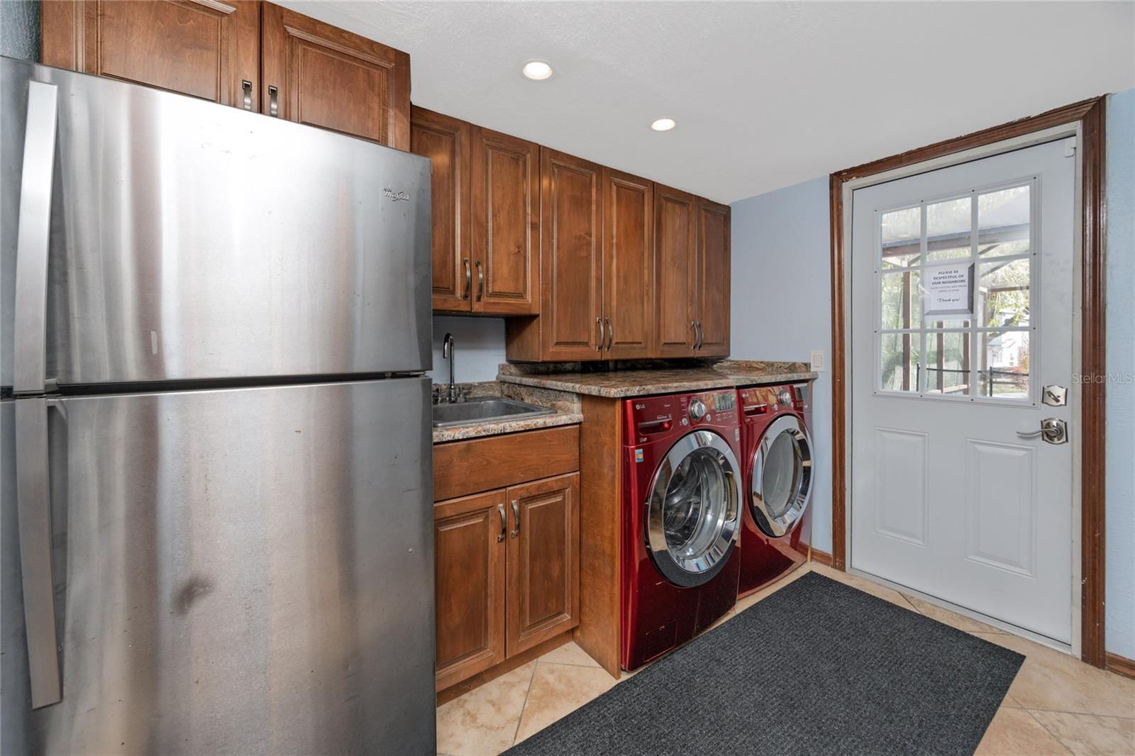 Laundry room with full size washer & dryer, brand new door to the pool area