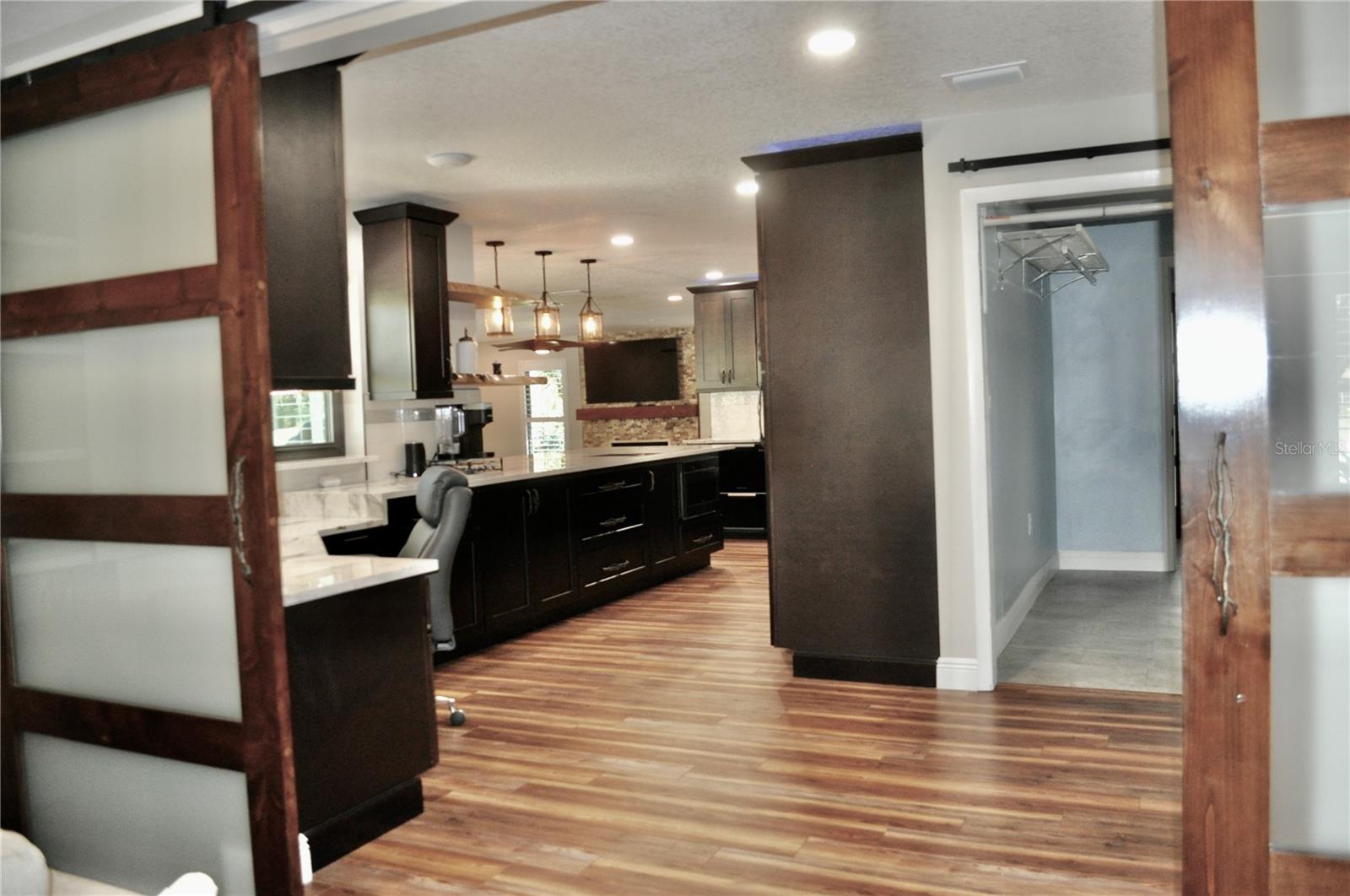 Beautiful sliding barns doors allow open flow for entertaining or added privacy into versatile media/family room from kitchen.