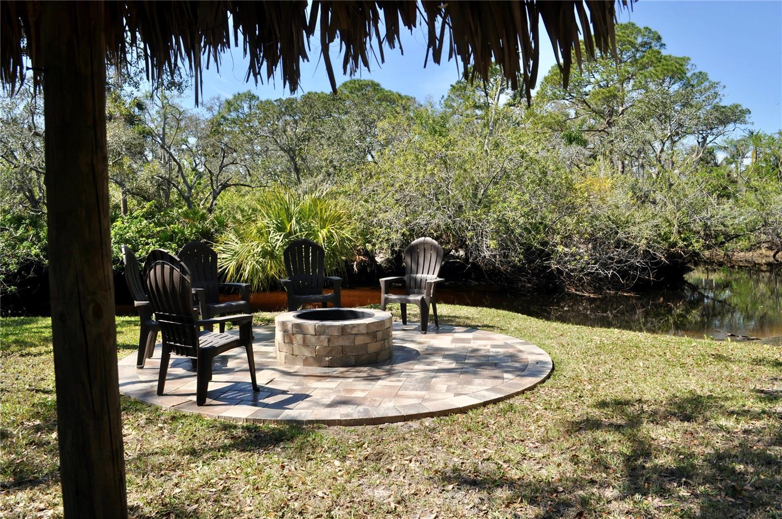 Paver fire pit overlooking nature-filled views and creek