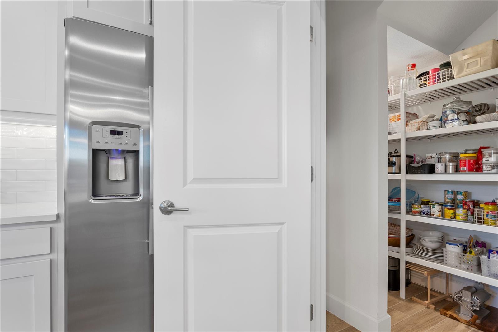 Walk-in pantry with built-in shelving.