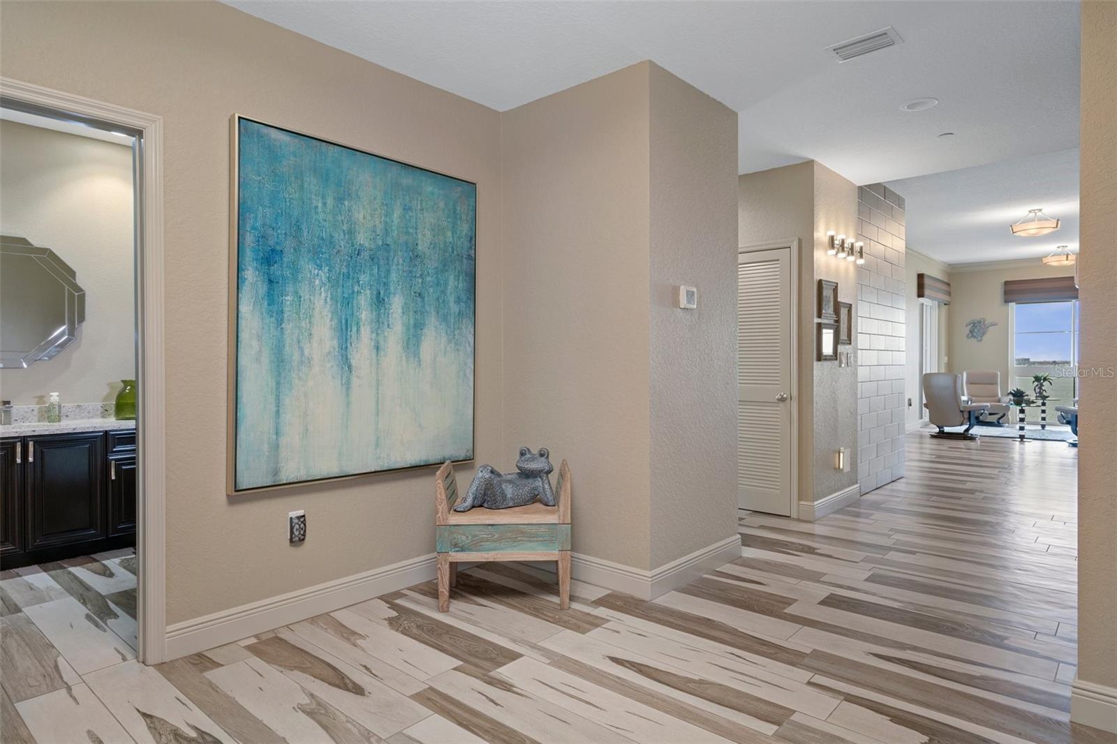 Entry Way opens to Half Bath with Water Views of the Living Room Beyond