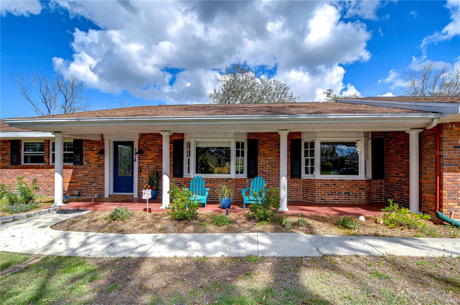 his home’s inviting porch, complete with cozy seating and vibrant brickwork, offers the perfect spot to unwind and enjoy the serene surroundings.