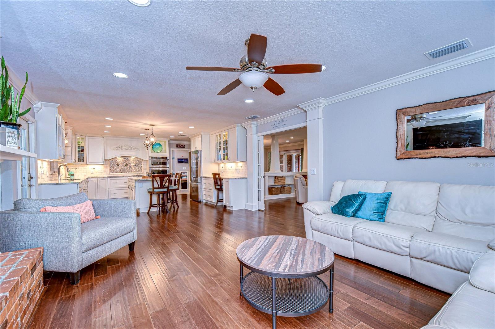 The open-plan living area features hardwood floors, cozy seating, and a beautifully updated kitchen, perfect for both relaxation and entertaining.