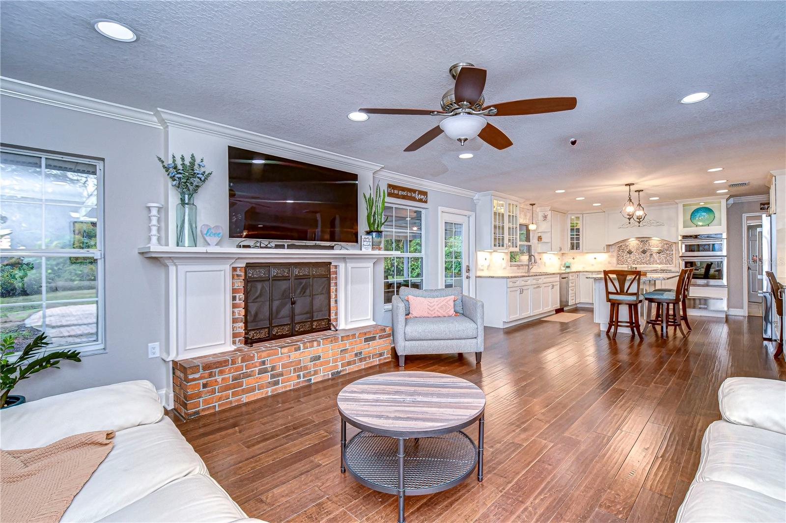 The warm hardwood floors and abundant natural light set the stage for relaxation and entertainment in style.