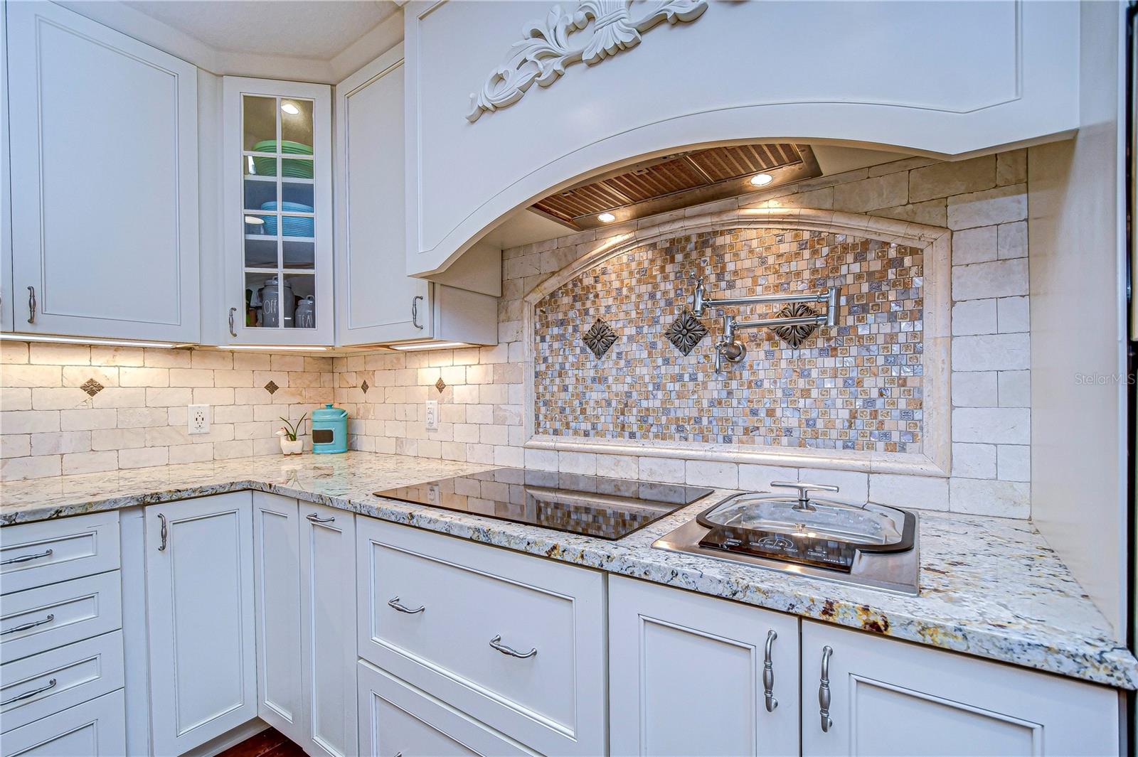 Elegant and efficient, this stunning kitchen shines with granite countertops and a custom backsplash. Its stylish cabinets and modern amenities make it the perfect spot