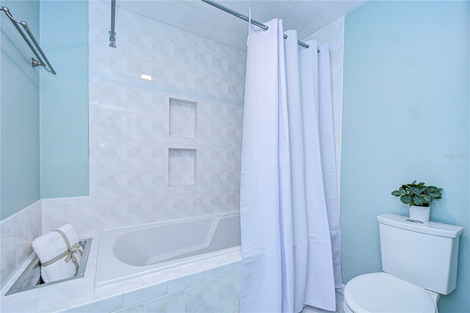 Step into tranquility with this spa-inspired bathroom, showcasing elegant tile work and a relaxing bathtub.