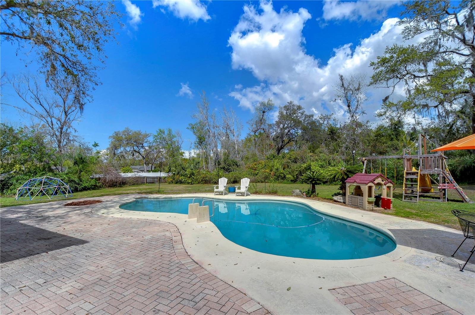 Dive into relaxation with this stunning backyard oasis featuring a sparkling pool, perfect for Florida sunshine.