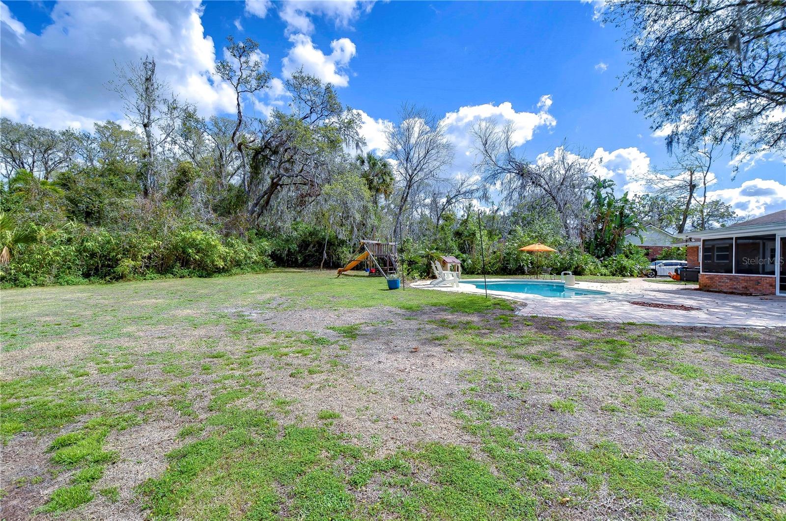 Discover your private oasis with this backyard—featuring ample space for play, a pool for sun-soaked relaxation, and lush greenery offering serene privacy.