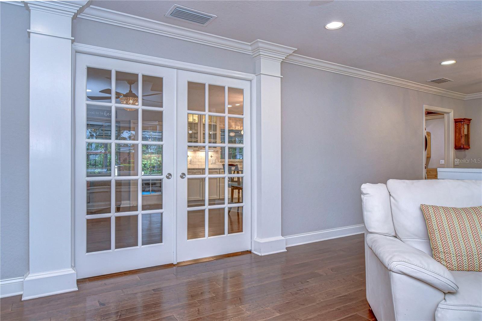 Elegant French doors invite you to discover the heart of this beautiful home, where natural light dances across stylish hardwood floors.