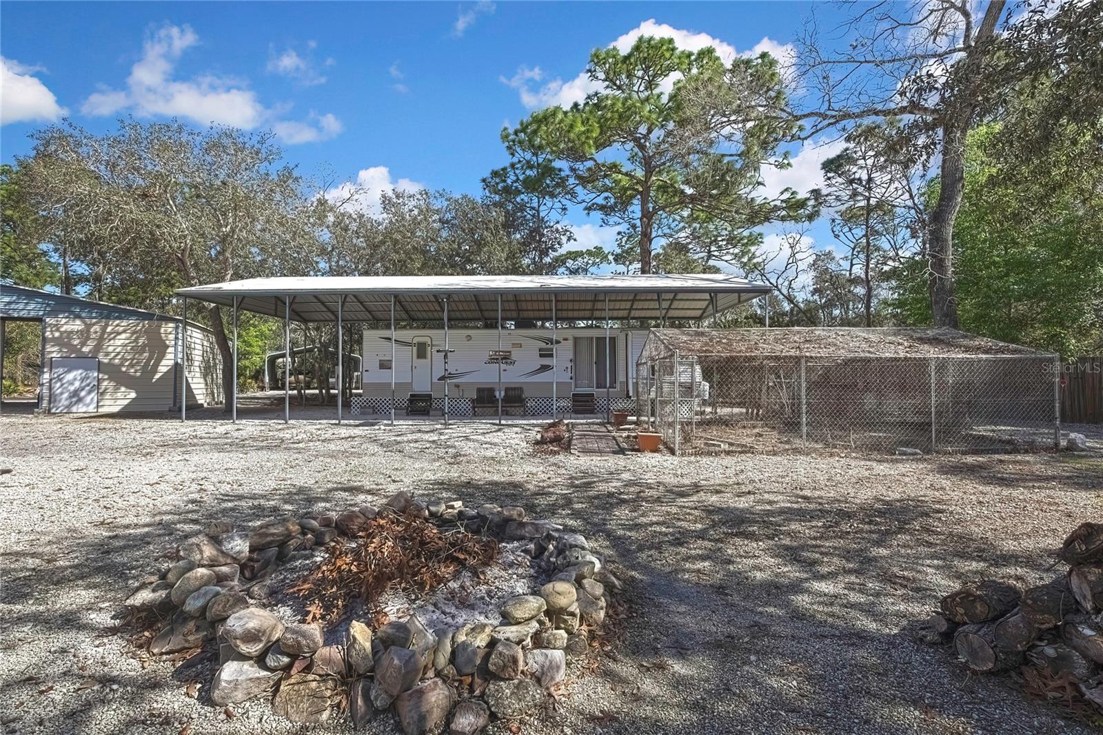 Fire Pit.   Attatched RV with own Power,  Well and Own Septic with Carport Cover. Shed # 4 & #5 with Carport and Enclosed Garden.