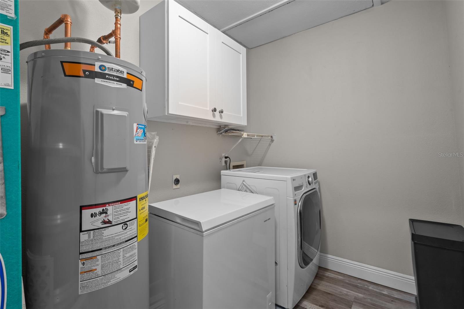 Laundry room with combo washer/dryer and freezer