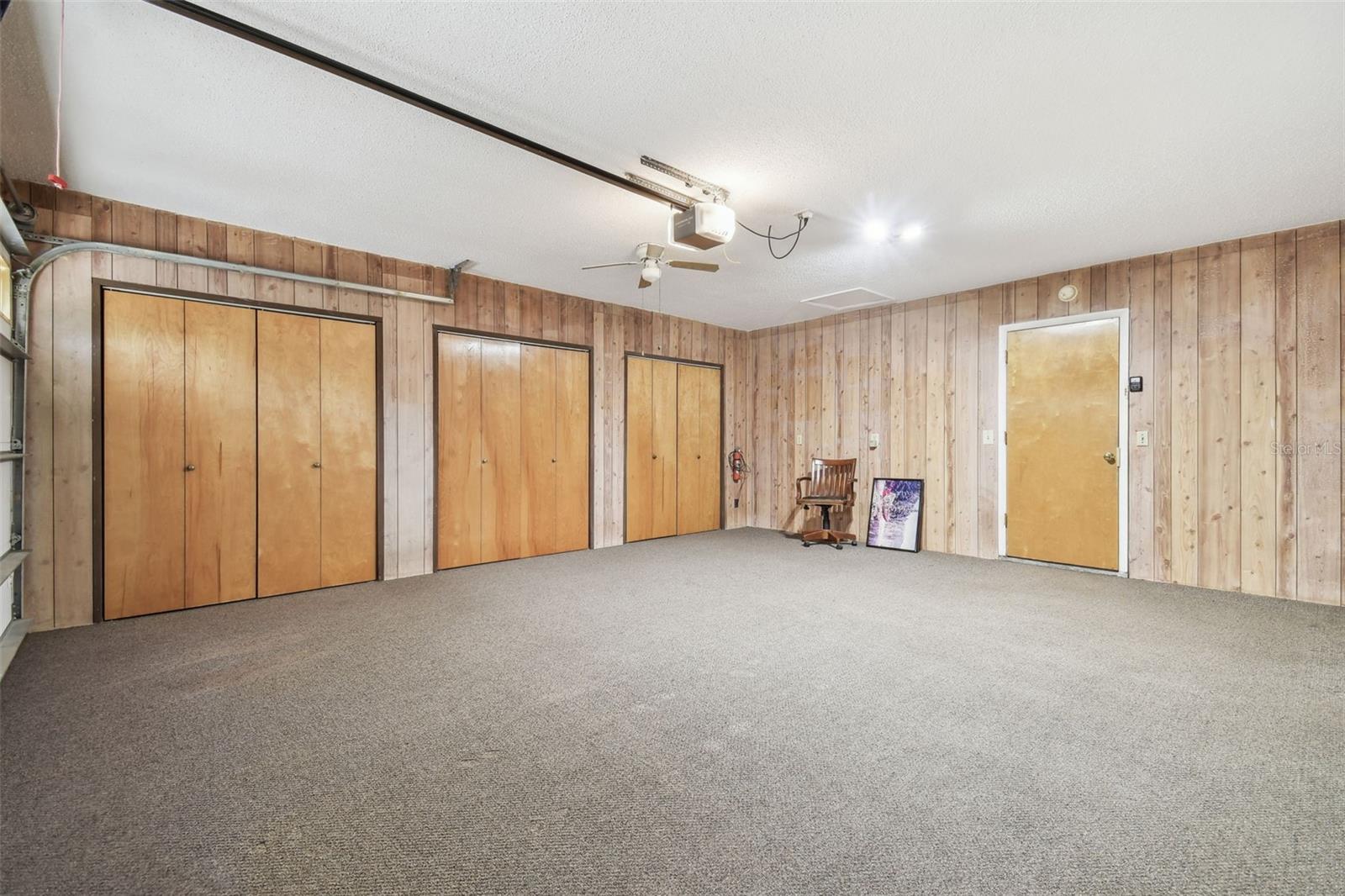 The garage is paneled and has large storage closets with shelving.