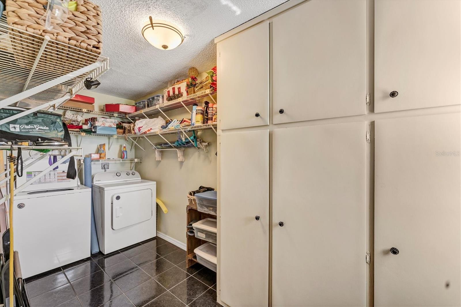 Huge laundry room with built in cabinets and shelves