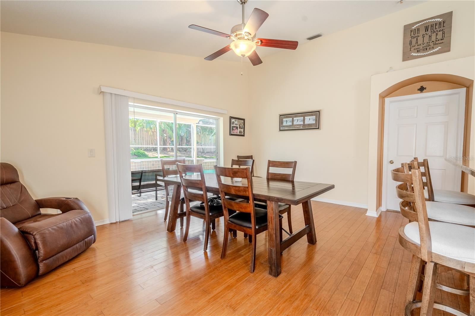 The family room has sliding glass doors that frame the view of the screened in lanai and pool.