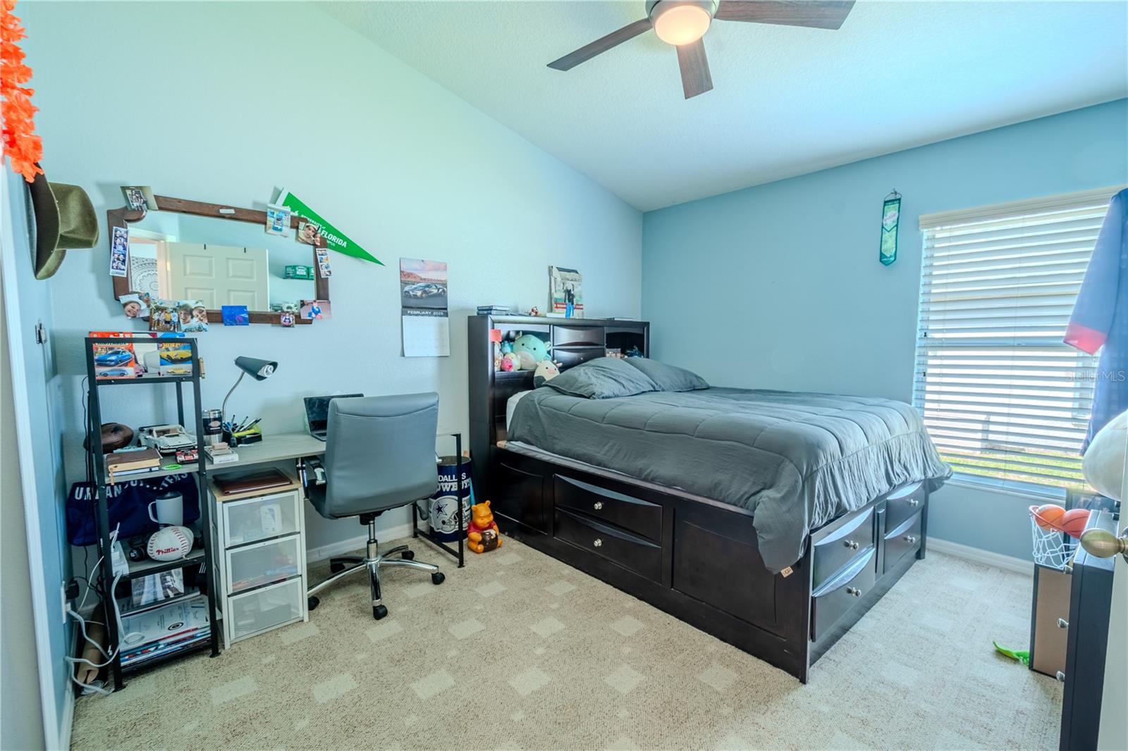 Bedroom 2 features neutraal tone carpet, a ceiling fan with light kit and a built in closet.