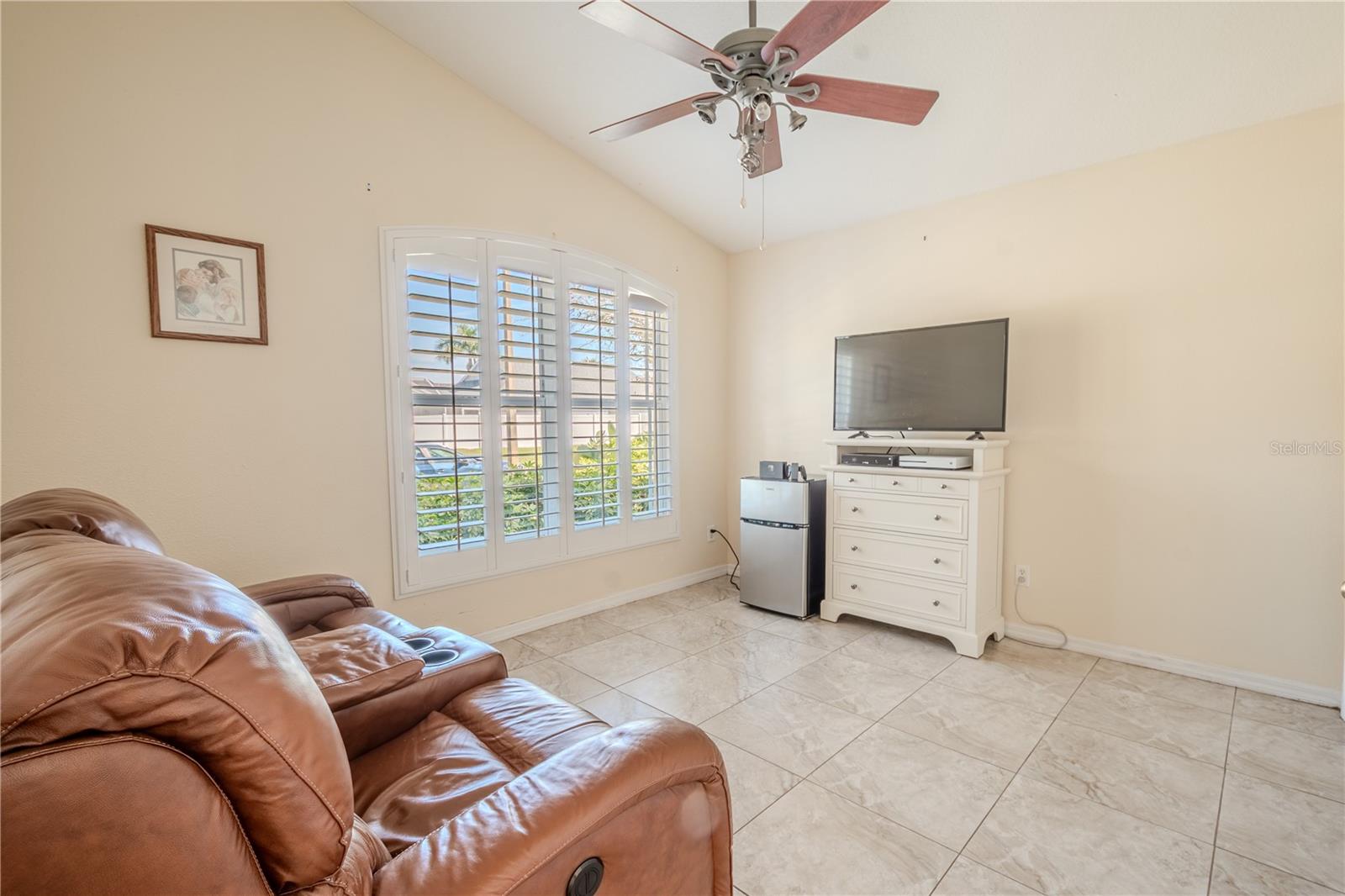 Bedroom 4, currently used as a den features neutral tones, a tile floor, a built-in closet, and a ceiling fan with light kit.