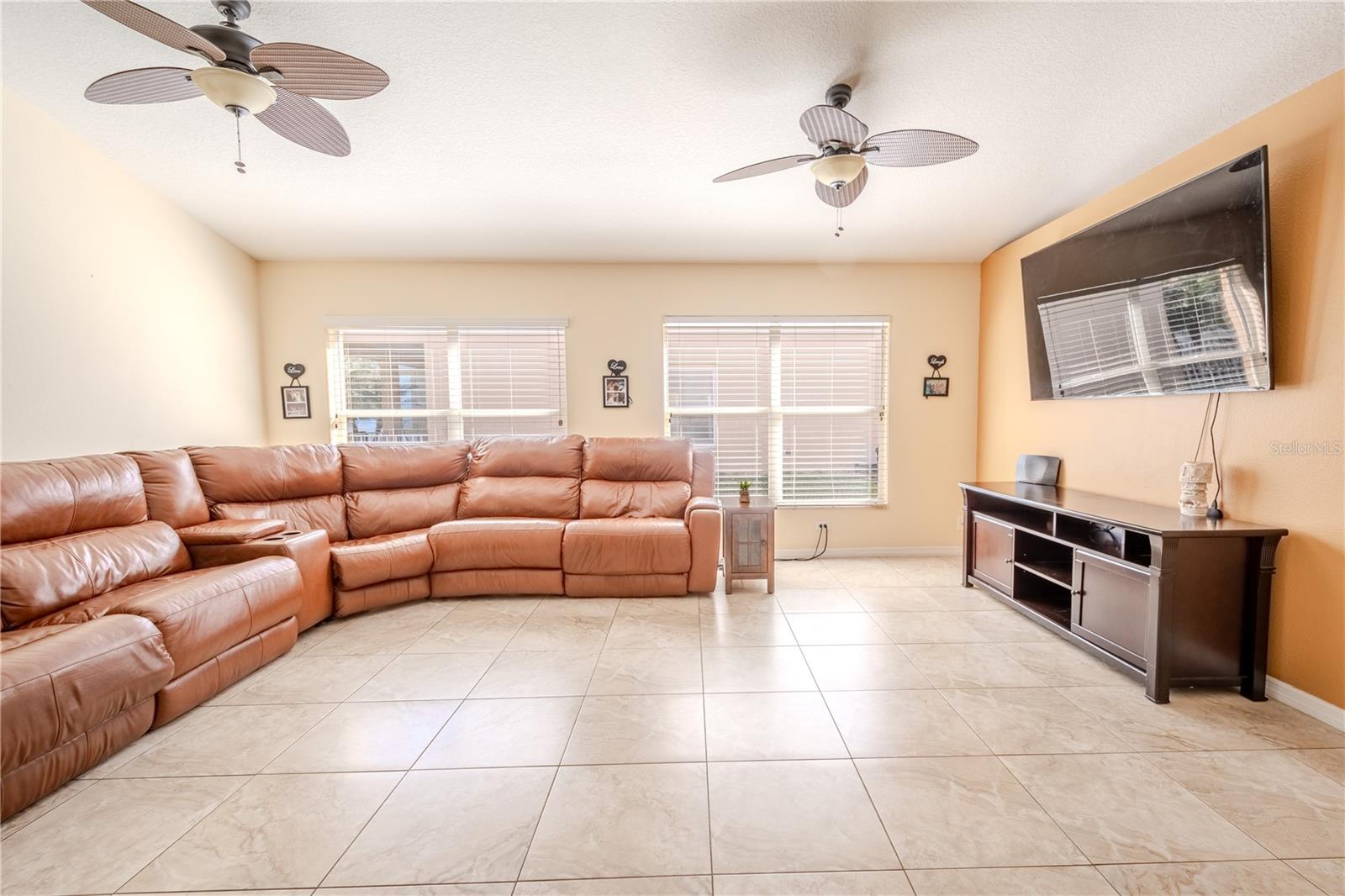 The living room gets plenty of natural light from two sets of double windows that frame the wall.