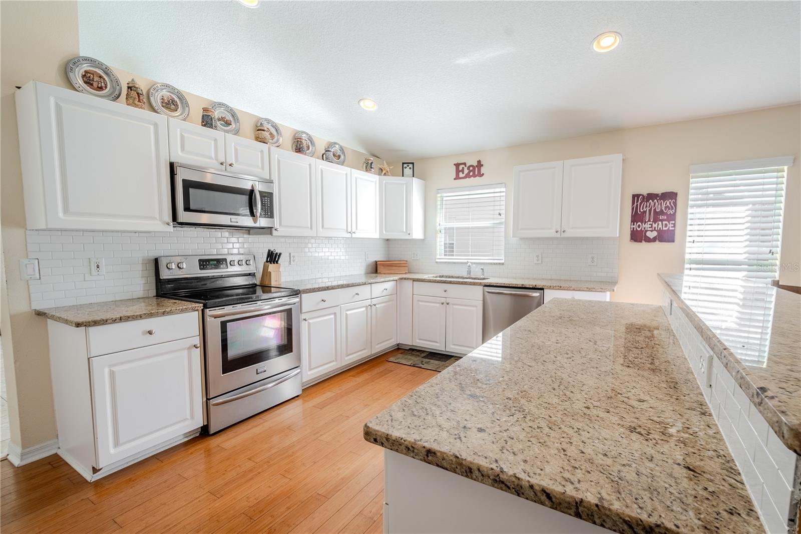 The kitchen features a suite of stainless steel appliances.