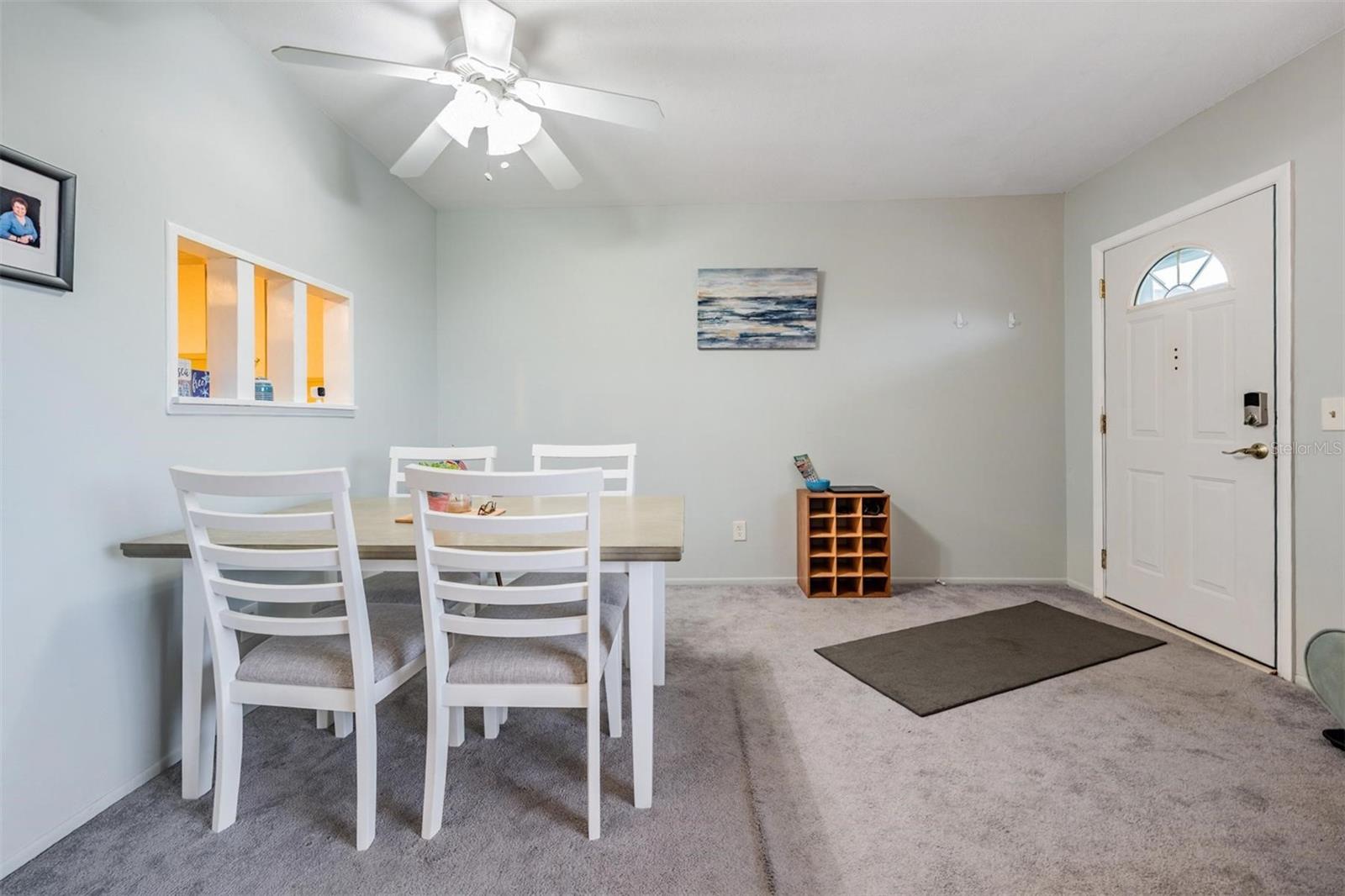 Dining area at front entry with passthrough window to kitchen.