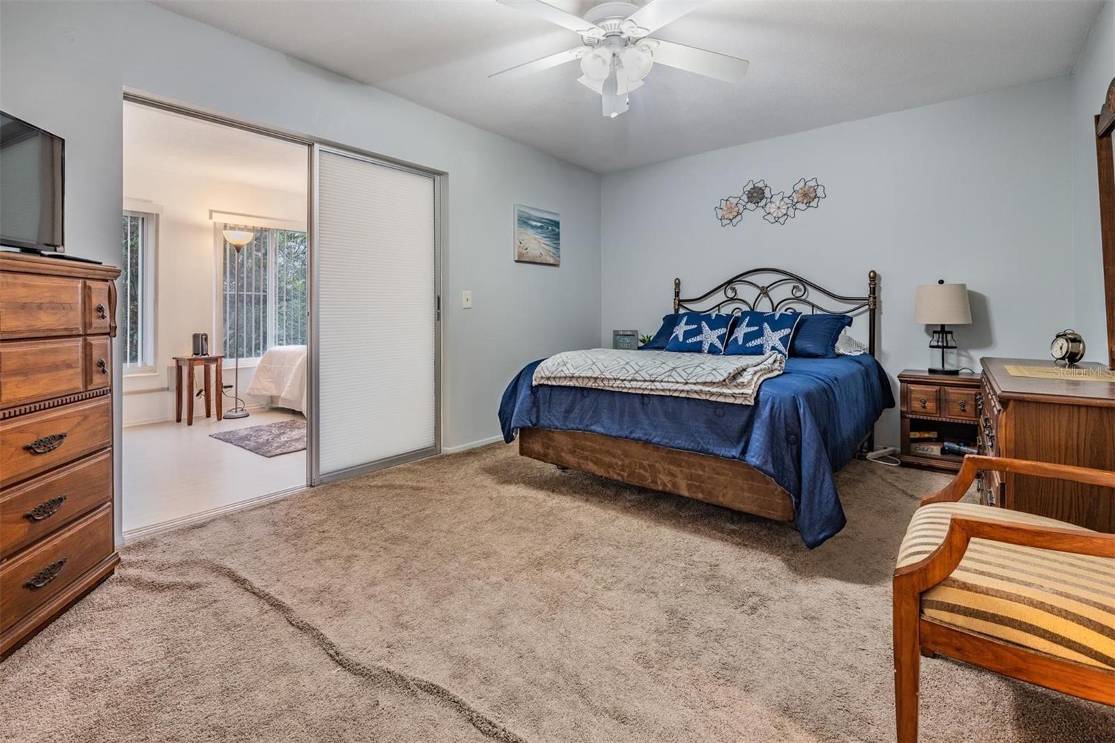 The spacious bedroom at the back of the unit offers a nice-sized closet and sliders out to the bonus room.