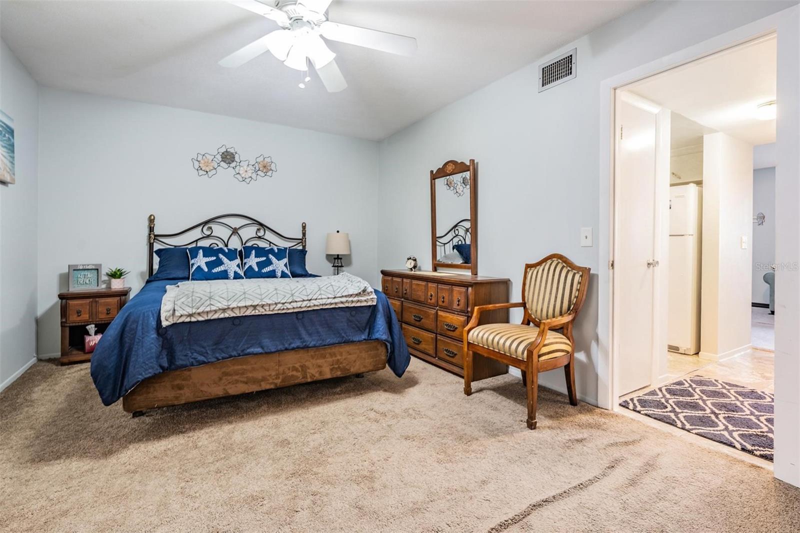 The spacious bedroom at the back of the unit offers a nice-sized closet and sliders out to the bonus room.