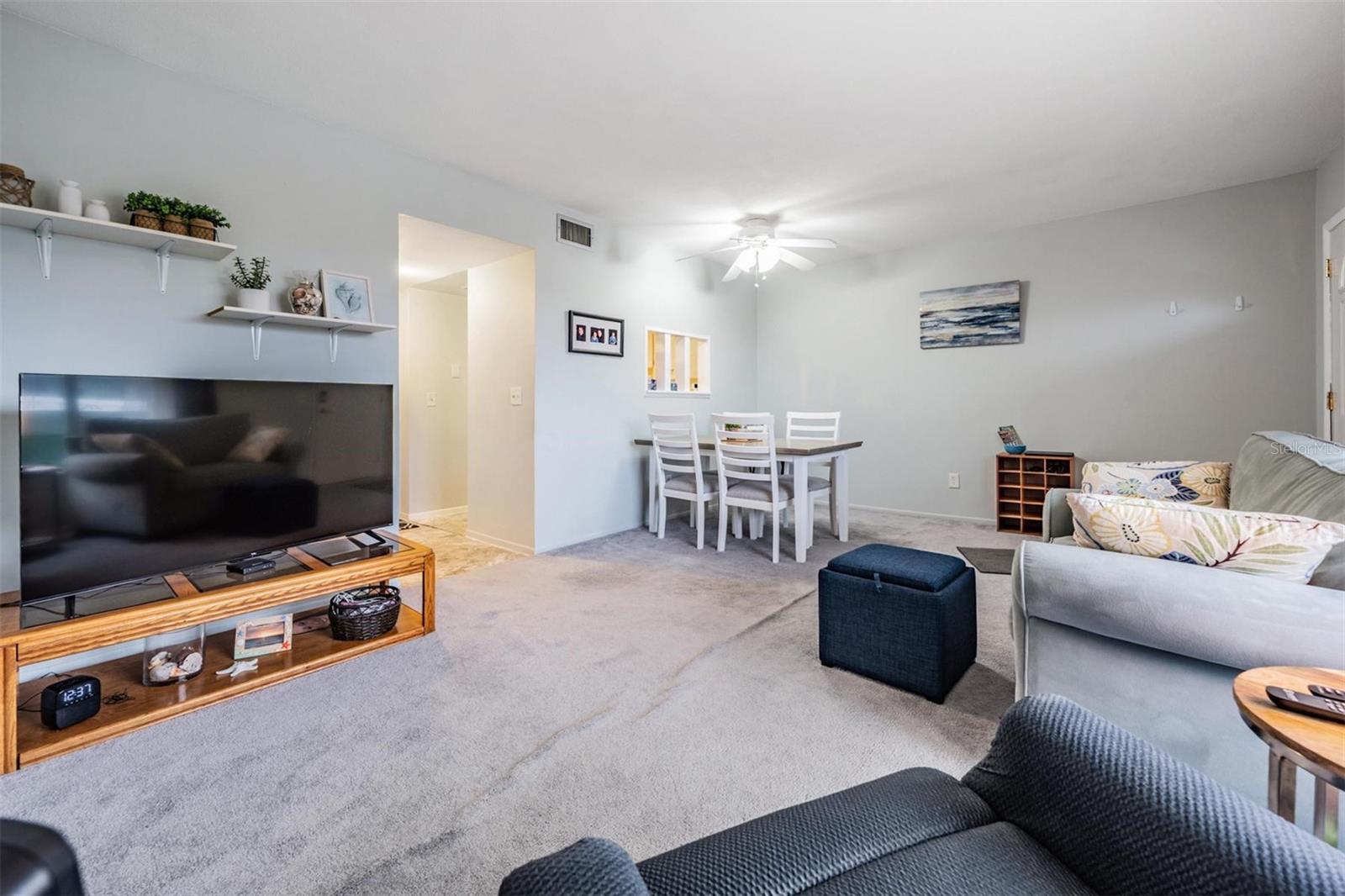 Enter home into Living room / Dining area with large picture windows and a passthrough window to the kitchen.