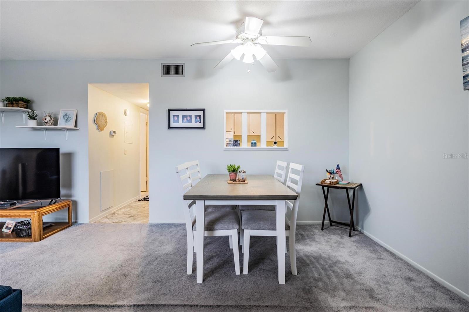 Enter home into Living room / Dining area with large picture windows and a passthrough window to the kitchen.