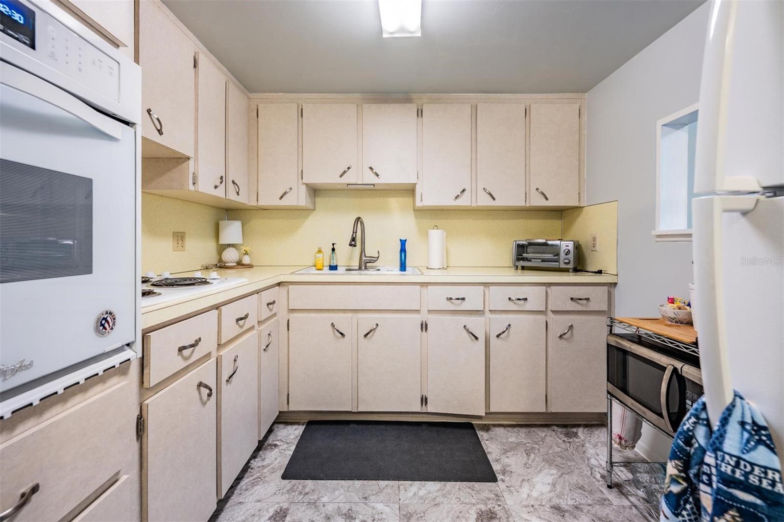 Well-equipped kitchen with plenty of cabinets and counterspace, and passthrough window to dining area.