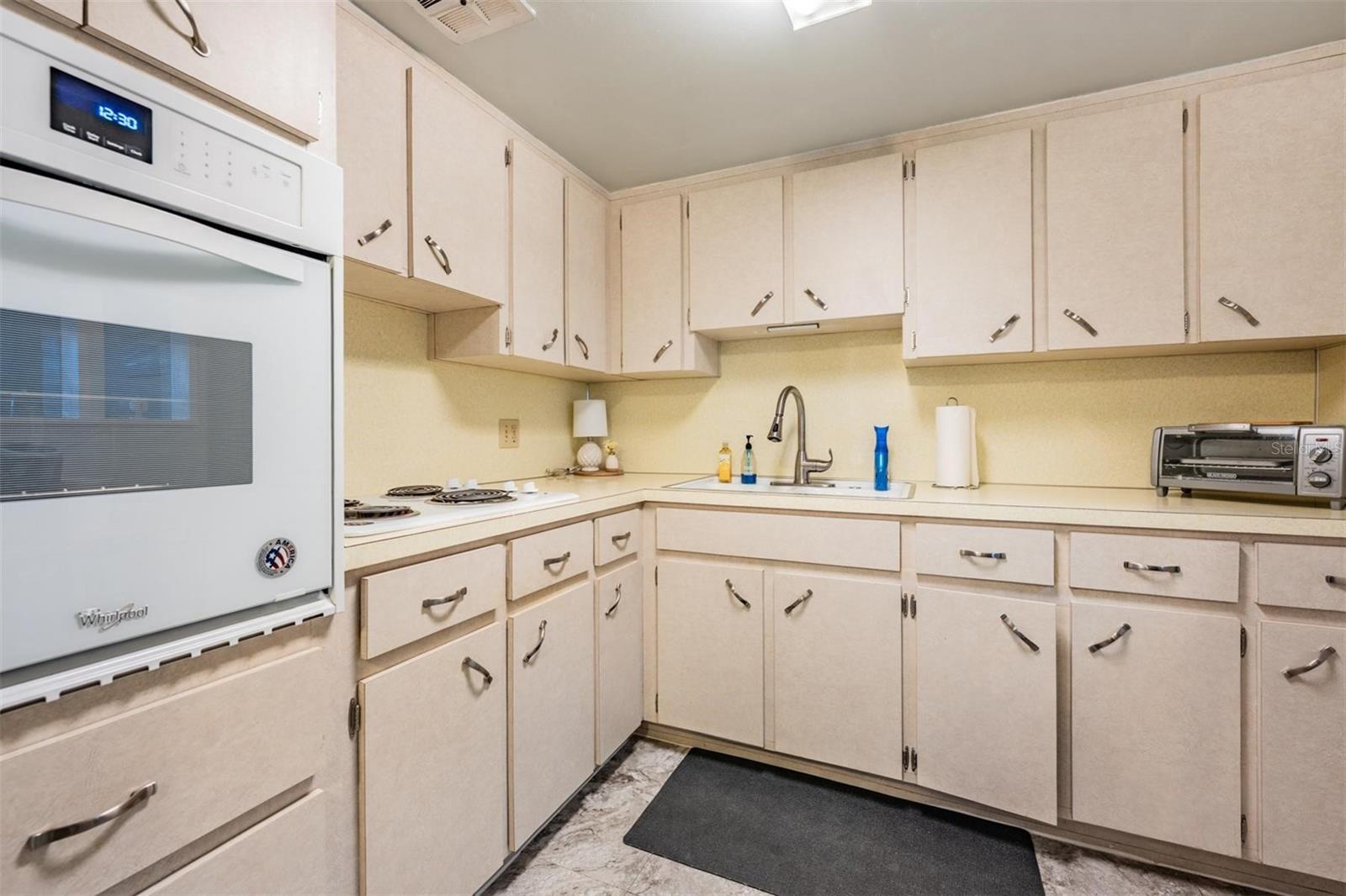 Well-equipped kitchen with plenty of cabinets and counterspace, and passthrough window to dining area.