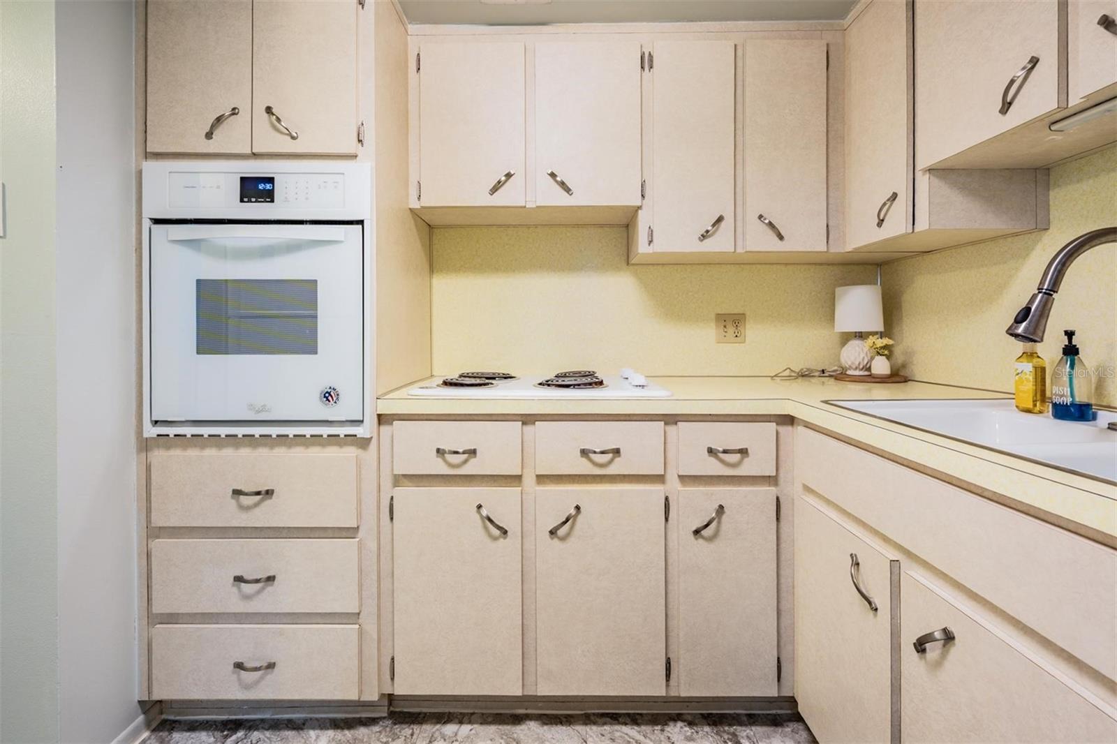 Well-equipped kitchen with plenty of cabinets and counterspace, and passthrough window to dining area.