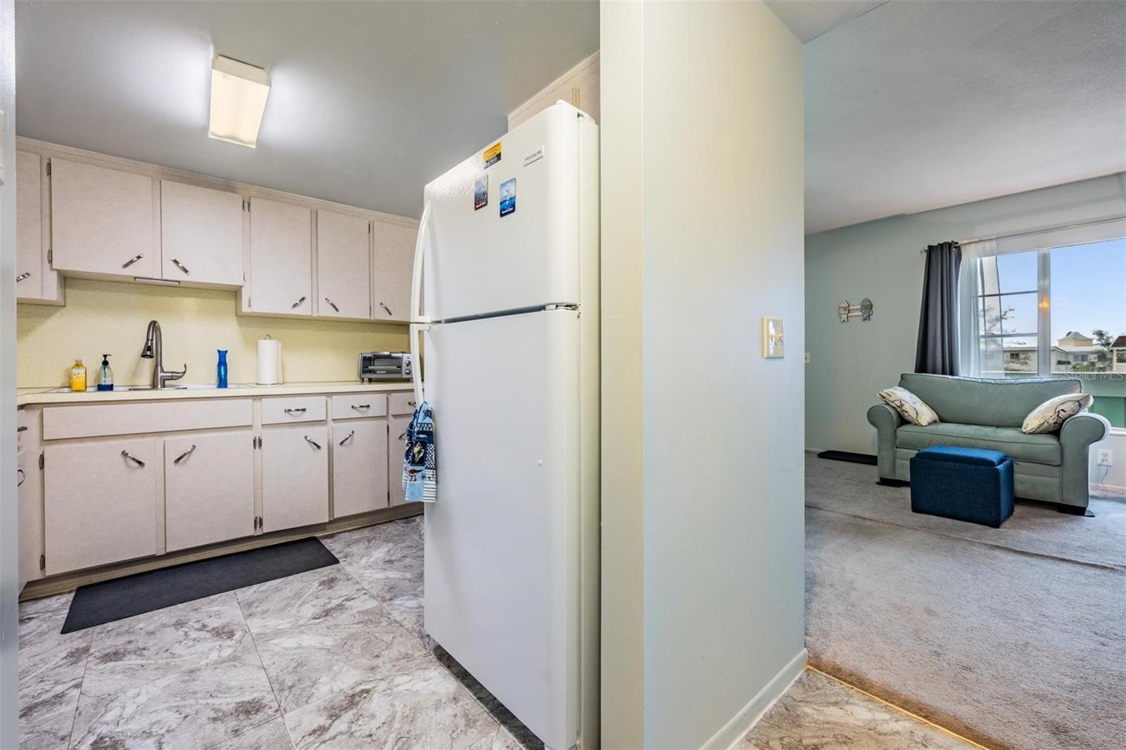 Well-equipped kitchen with plenty of cabinets and counterspace, and passthrough window to dining area.