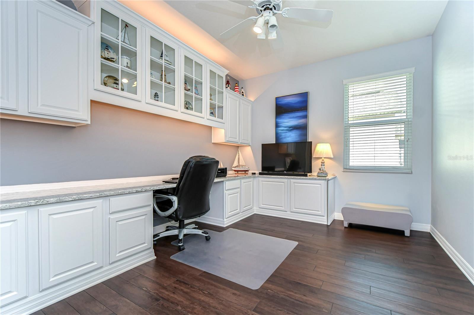 Elegance meets functionality in this stunning home office space, featuring custom built-in cabinetry, sleek countertops, and ample natural light.