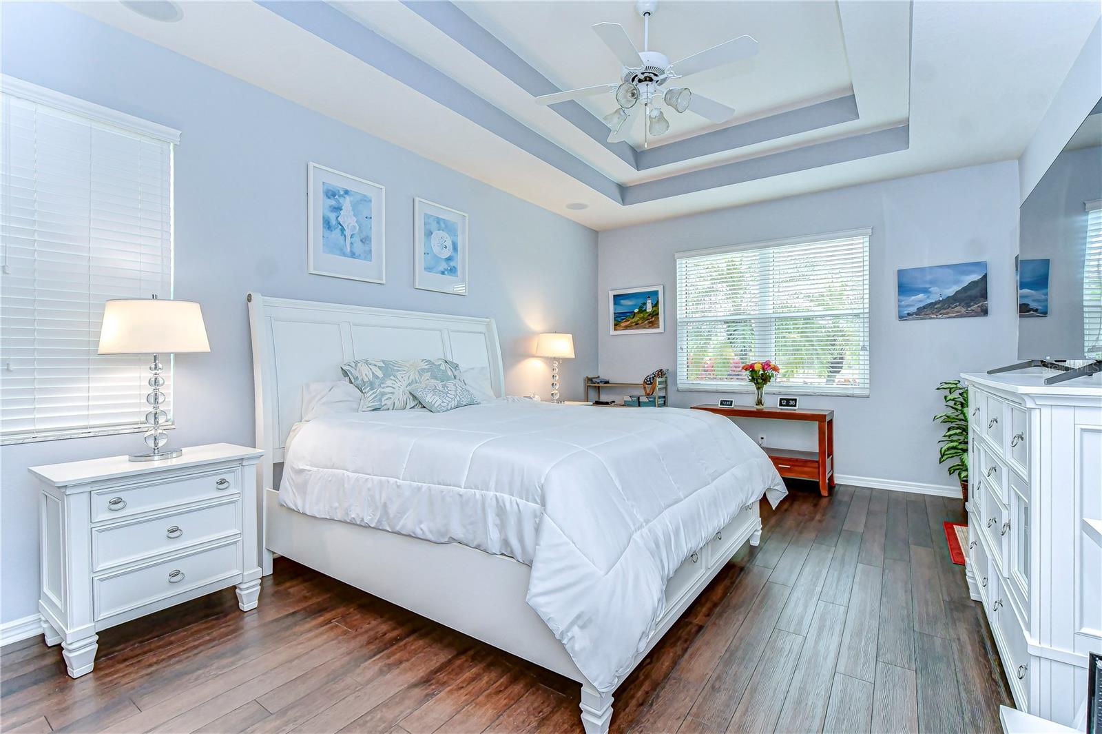 Serene and spacious, this primary bedroom offers a retreat with chic tray ceilings and abundant natural light