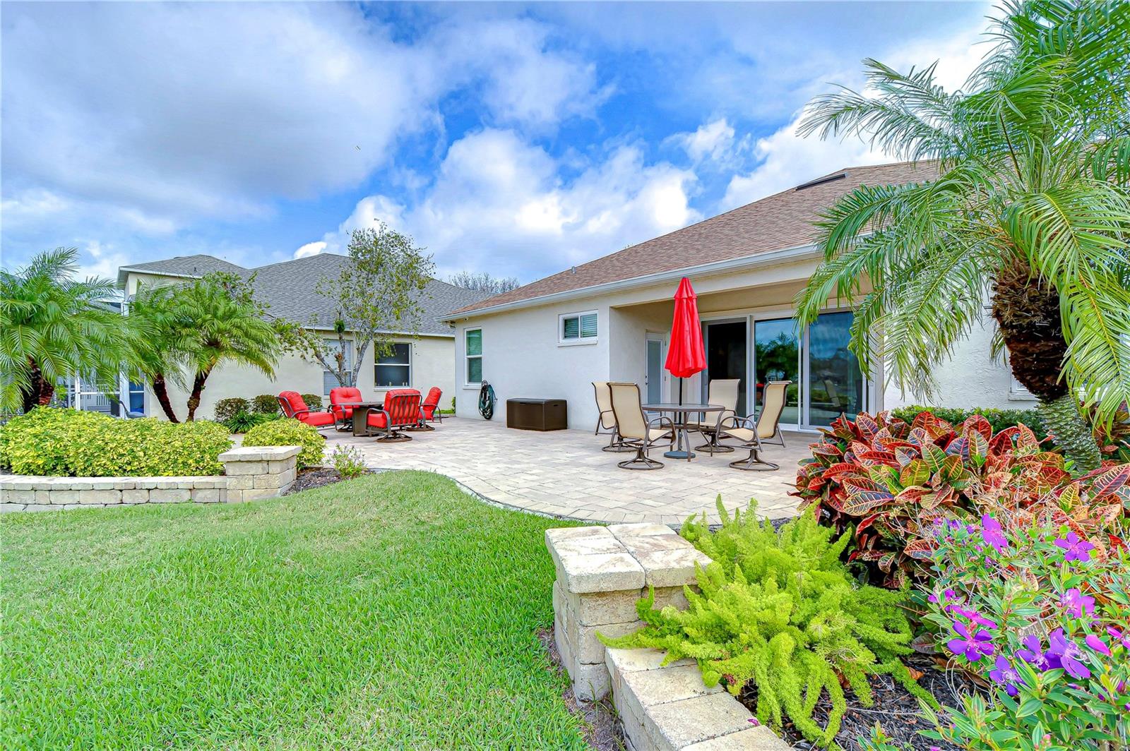 This spacious patio invites you to soak in the vibrant Florida sun amidst lush greenery