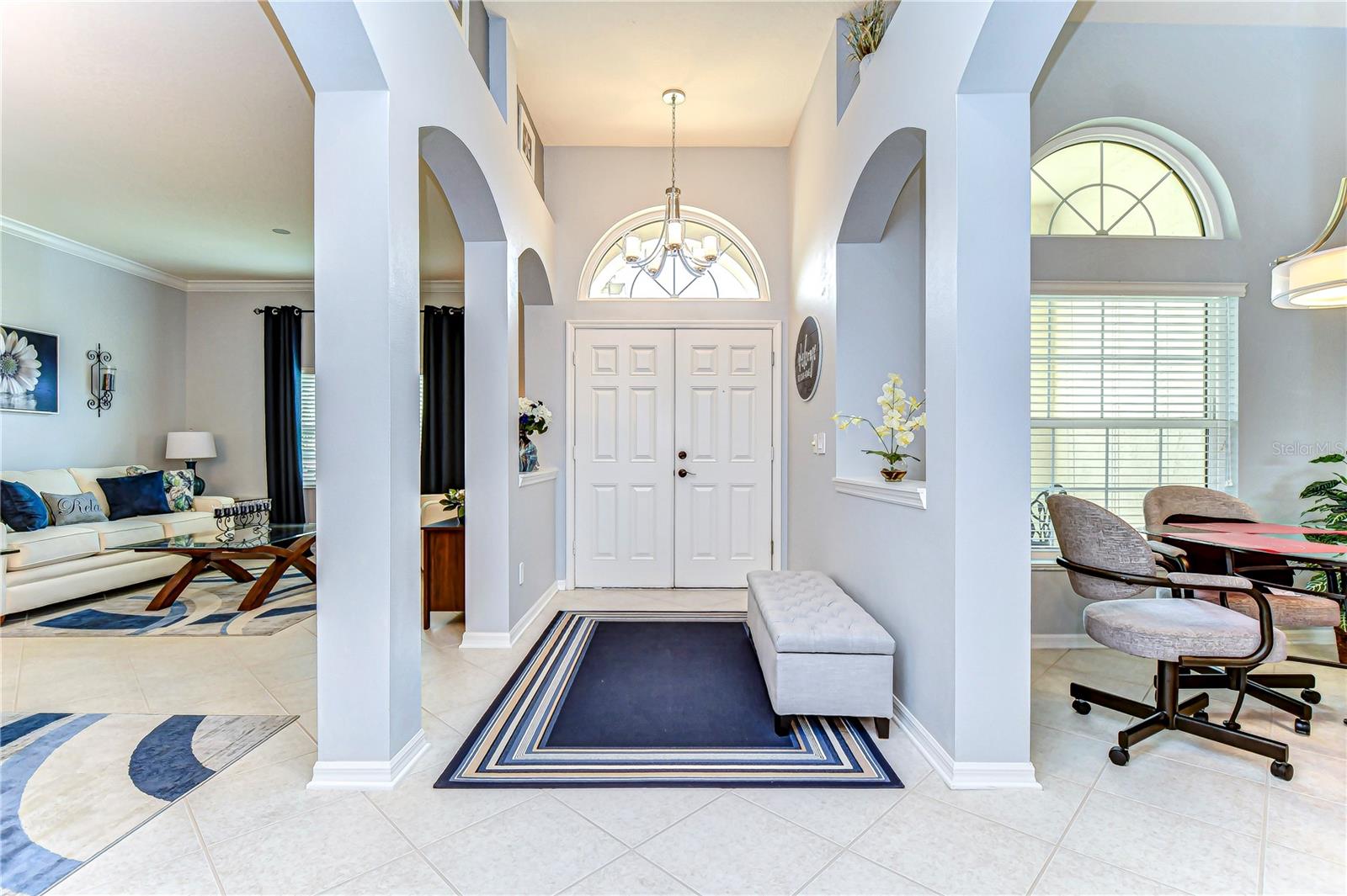 Step into elegance with a welcoming entryway featuring high ceilings and arched details.