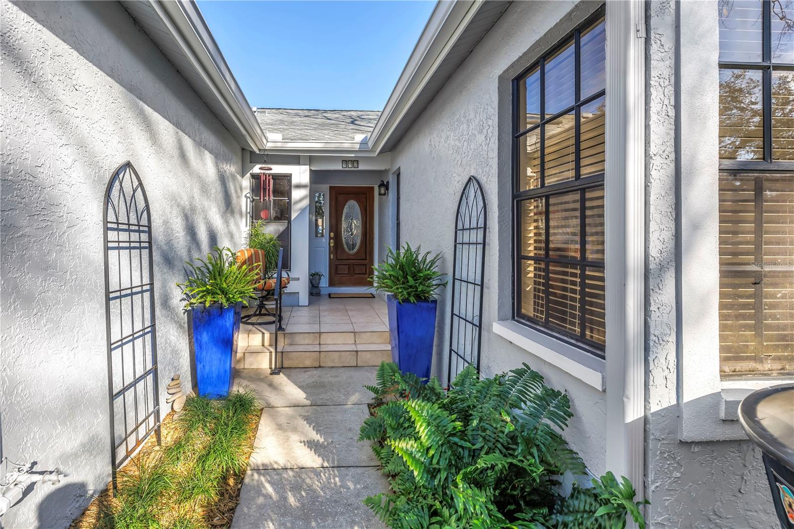 Front Courtyard and Entry with Landscape plantings and covered front door
