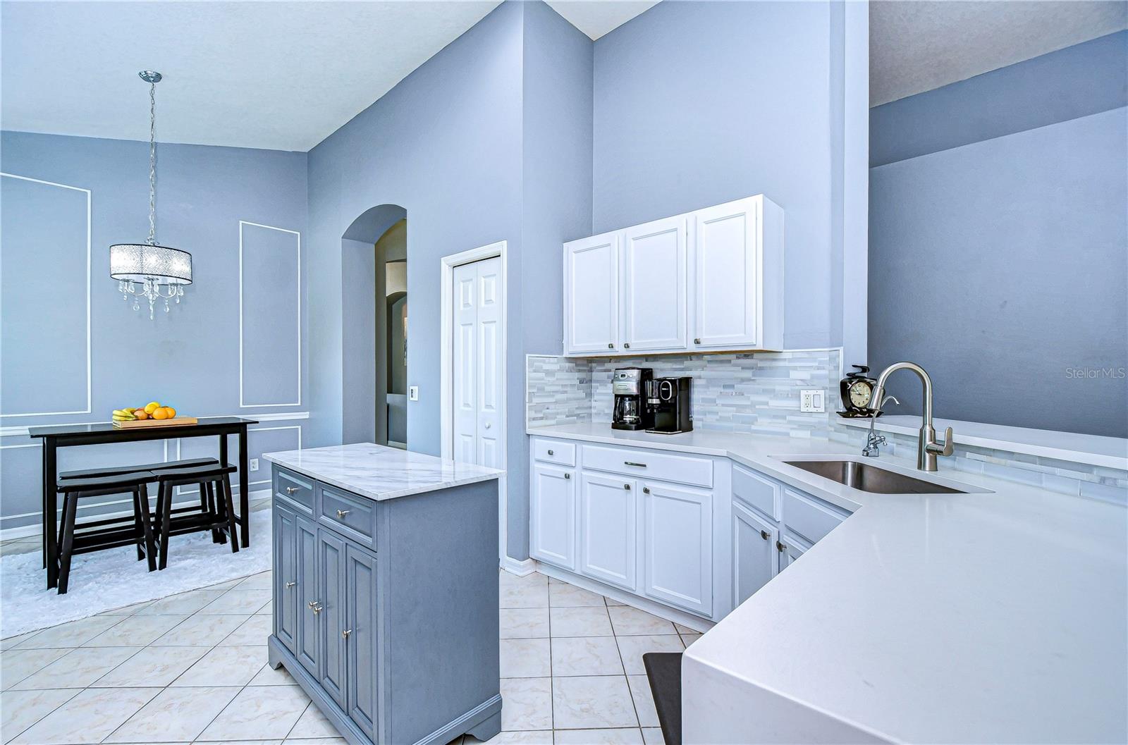 Step into a freshly updated kitchen with sleek white cabinetry and a chic breakfast nook perfect for morning coffee.