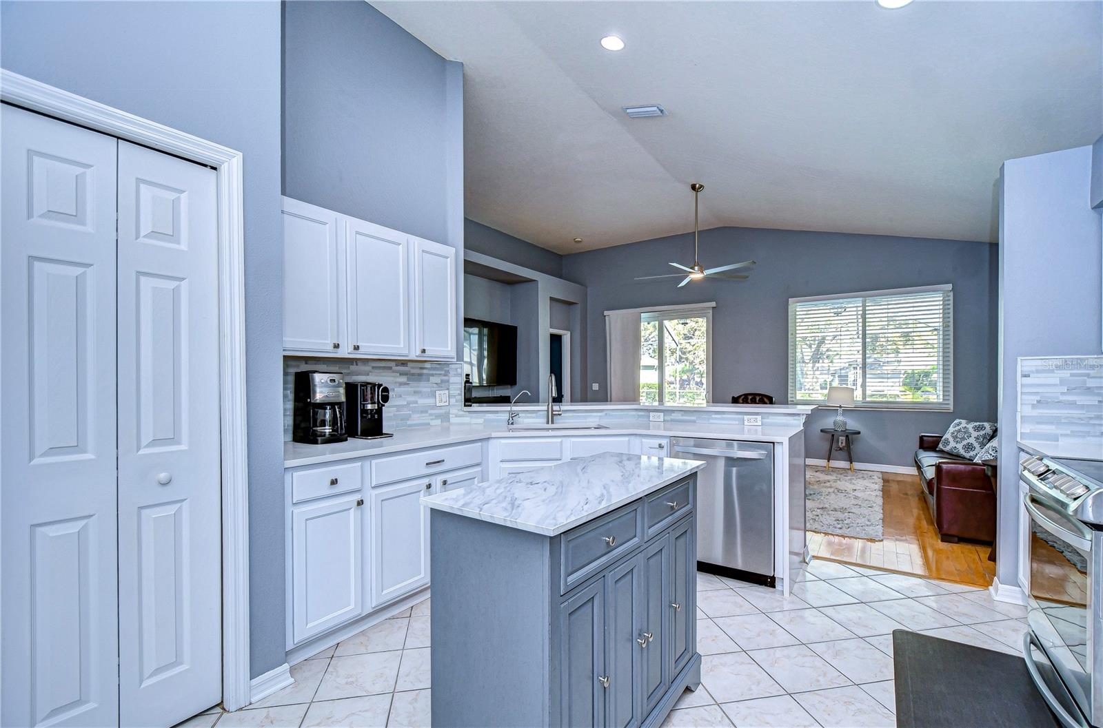 This stunning kitchen offers a harmonious blend of elegance and functionality, featuring sleek white cabinetry, a chic island, and ample natural light.