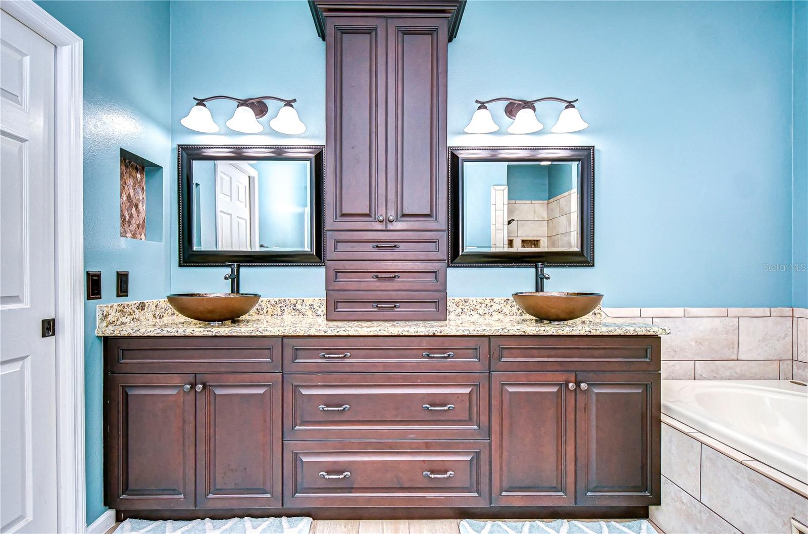 Elevate your mornings in this luxurious bathroom boasting dual vessel sinks and rich wood cabinetry.