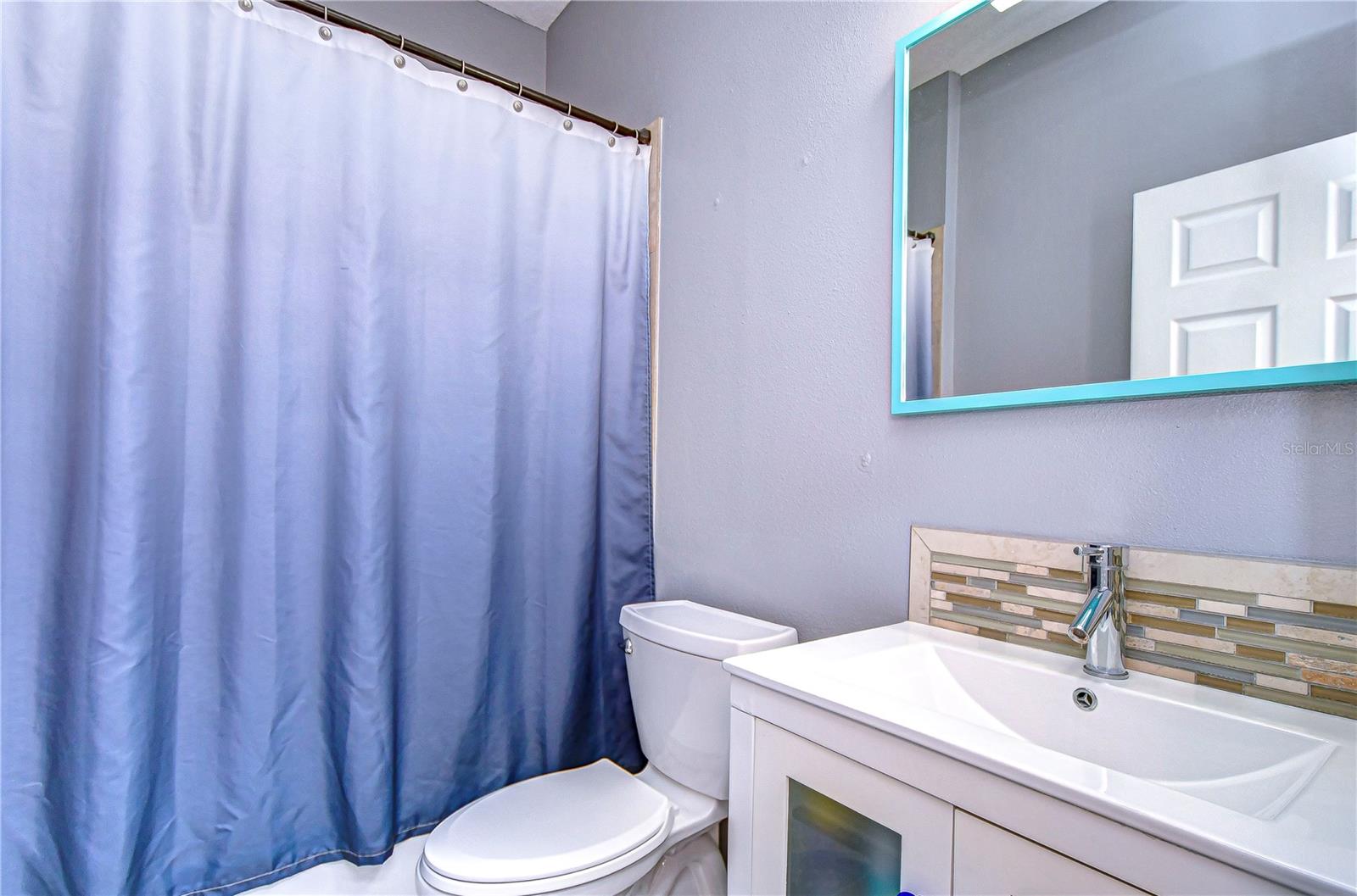 Step into a refreshed bathroom featuring a stylish vanity and thoughtfully designed backsplash.