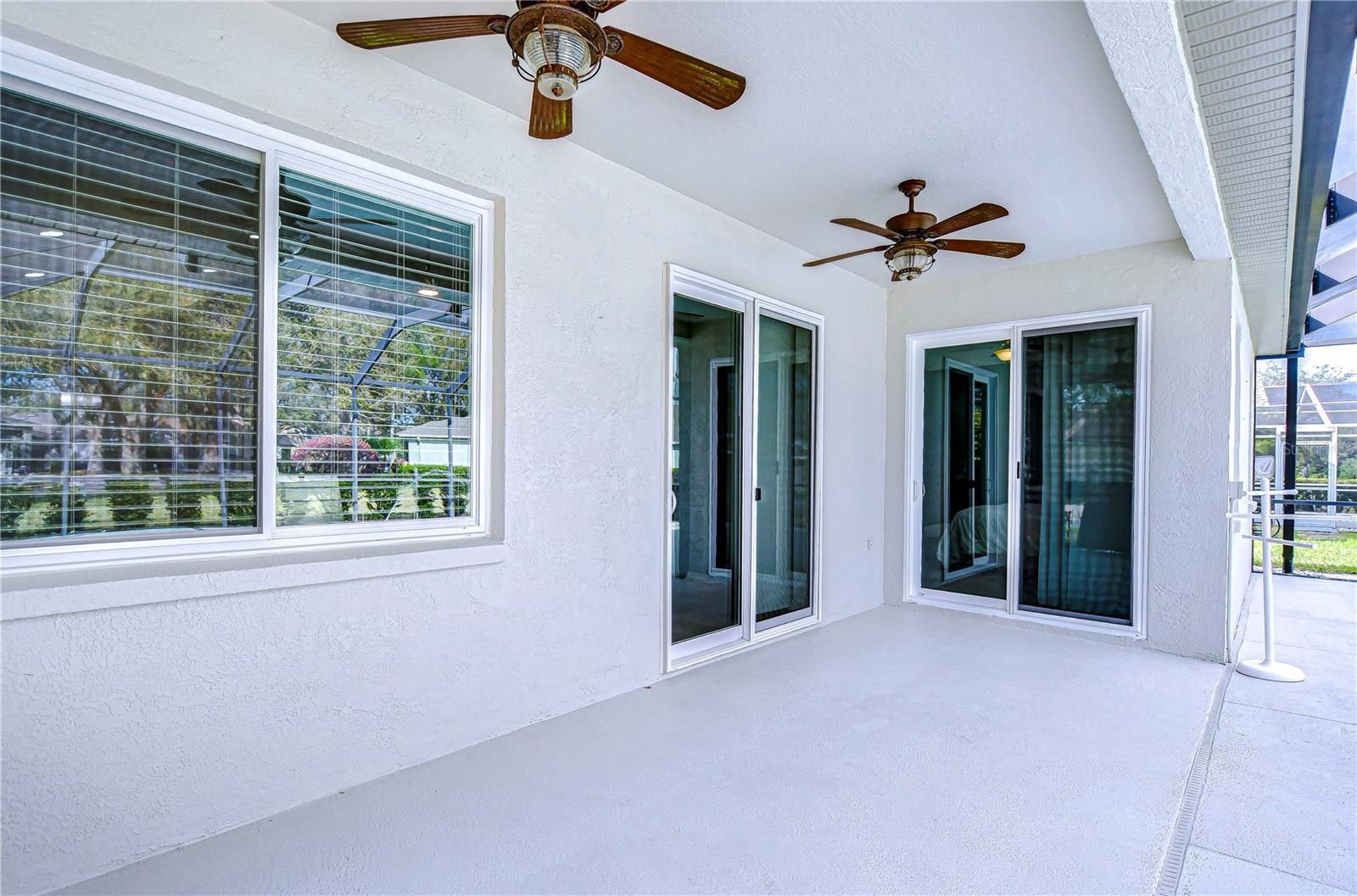 Step into relaxation on this charming patio, featuring dual ceiling fans for a breezy retreat.