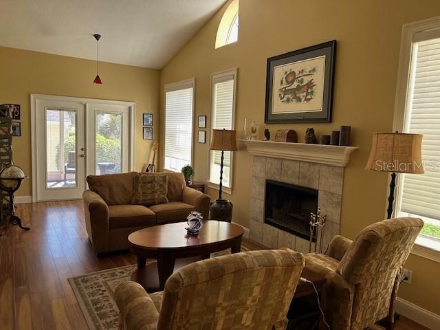 Light & Bright Family room with high volume ceiling & wood burning fireplace.