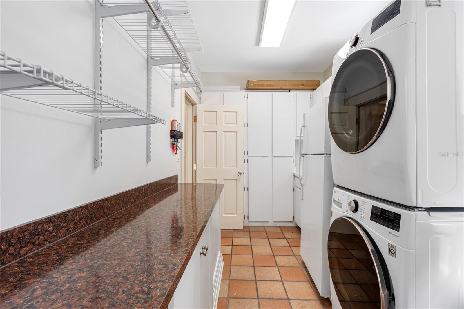 Large laundry room with LG washer and dryer (3 years old) and an adittional refrigerator.